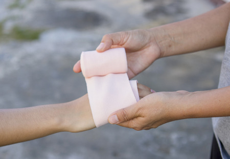 Volunteers are provided to patient wrist wrap Elastic Bandage, with patient wrist injury.