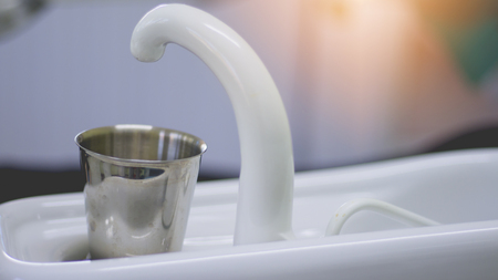 Blurred image of glass of water and water systems, dental treatmentの写真素材