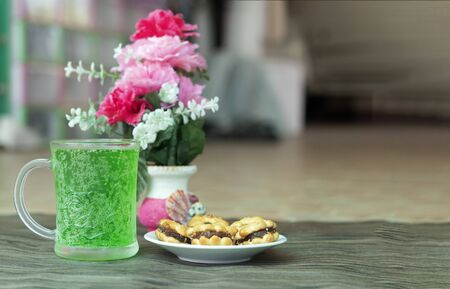 Sweets and sweet green water and prepared for a light meal on the floor with wooden boards.の写真素材