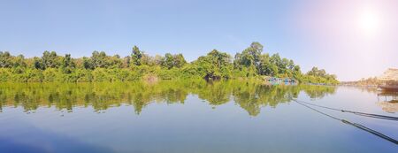 Panoramic forest green riverbank. And the well-being of the people along the river.の写真素材