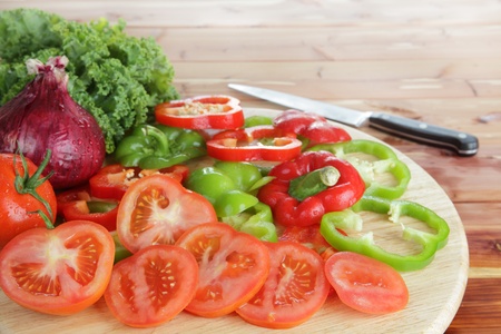 Salad ingredients including tomatoes, kale, onions, and red and green peppers