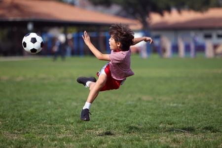 Boy playing soccer in the park - authentic action - horizontal with copy spaceの写真素材