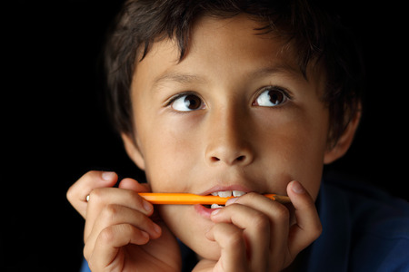 Portrait of thoughtful young school boy with chiaroscuro lighting - shallow depth of fieldの写真素材