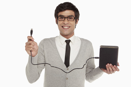 Man holding up an external hard discの写真素材