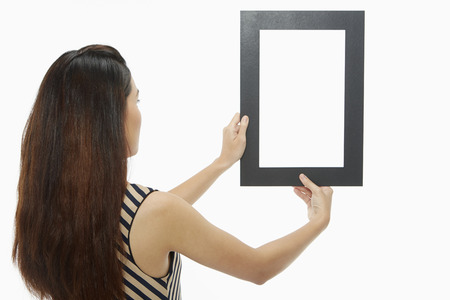 Woman holding up a black frame