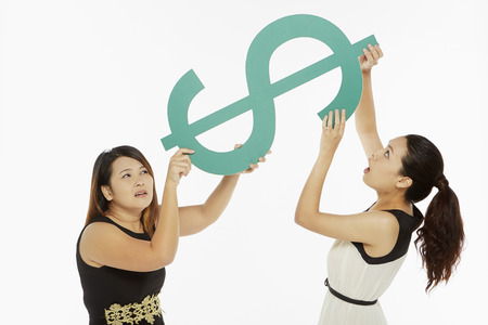 Women lifting up a dollar signの写真素材