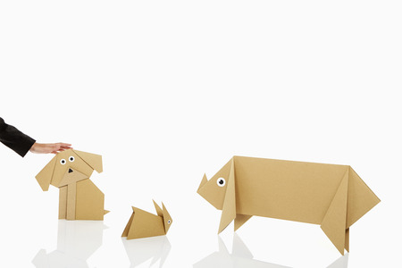 Human hand petting a paper dogの写真素材