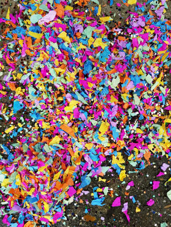 colorful red, yellow and green heart and circle confetti on a streetの写真素材