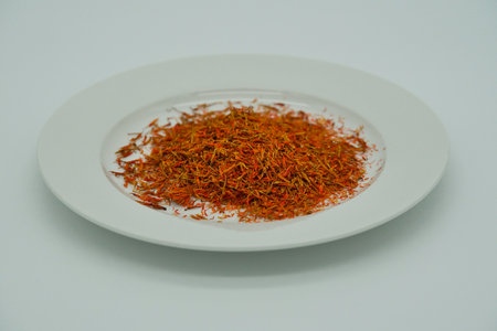 White plate with dried saffron on it against a dark backgroundの写真素材