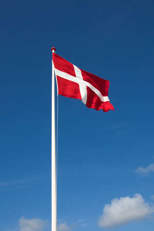 The denmark or danish flag with blue sky on backgroundの写真素材