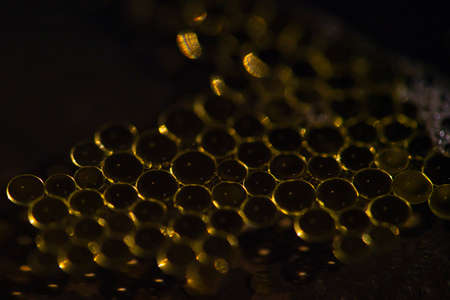 Oil drops on a water surface with dark backgroundの写真素材