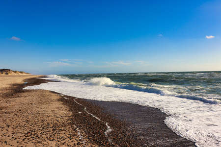 Panoramic view of Baltic sea from sandy shore, sand dunes. Dramatic sky with glowing clouds, sunbeams. Denmarkの写真素材