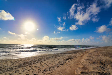 Panoramic view of Baltic sea from sandy shore, sand dunes. Dramatic sky with glowing clouds, sunbeams. Denmarkの写真素材