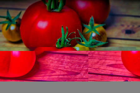 Ripe tomatoes on the vine on rustic wooden backgroundの写真素材