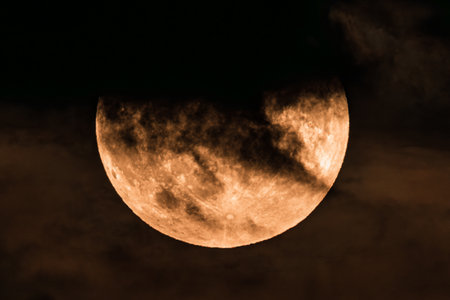The night sky holds a mysterious moon, creating an eerie atmosphere with clouds drifting by