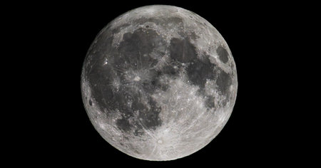 Sharp full moon photograph showing detailed craters and surface textures against a deep black sky....