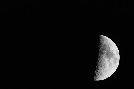 Waxing Moon Phase with Detailed Lunar Craters Against Black Sky