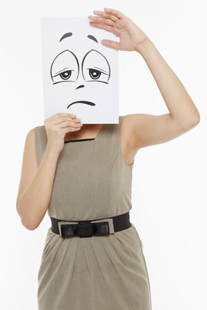 Woman holding up a sad face doodleの写真素材