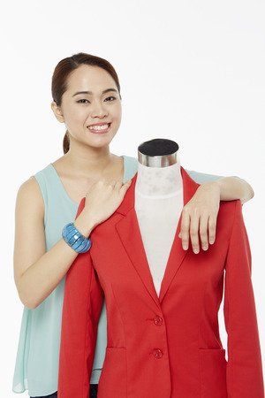Woman holding on to a mannequin, smilingの写真素材