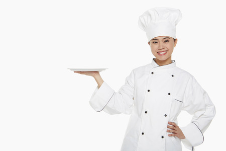 Female chef holding up a trayの写真素材