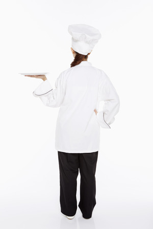 Female chef holding up a trayの写真素材