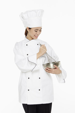 Female chef using a wire whiskの写真素材