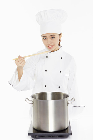 Female chef cooking and tastingの写真素材