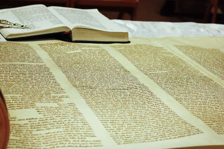 Torah scrolls; is on the table; wooden handles; gold nozzle holder; close up