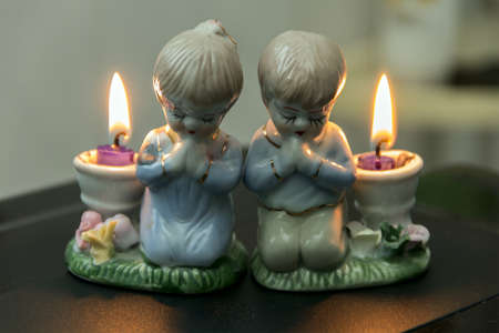 two lighted candlesticks distributed as ceramic candlesticks figure girl and boyの写真素材