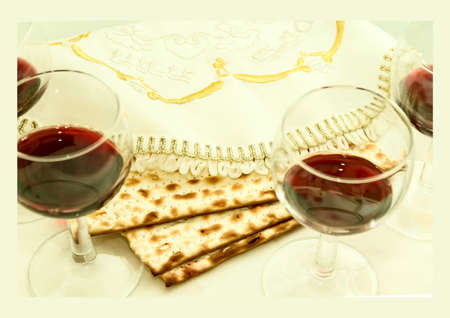 the symbol of the Easter holiday, three pieces of matzah, four glasses filled with wine, white cloth with embroidery and font on the Hebrew Pesach, on a white background, isolatedの写真素材