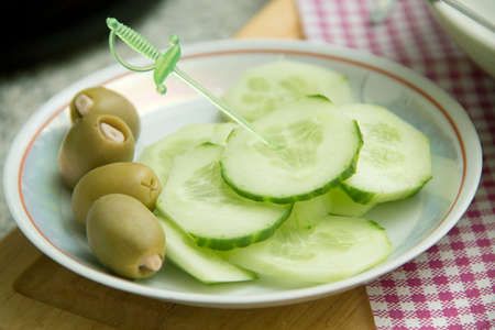 green olives stuffed with walnuts, cucumber cut by mugs, wall in the form skewersの写真素材
