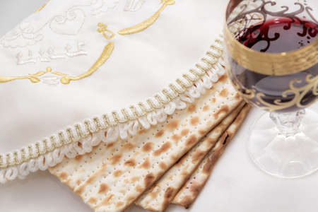 Matzen lying on the plate covered with bestrikten napkins, wine glass with red wine, close-upの写真素材