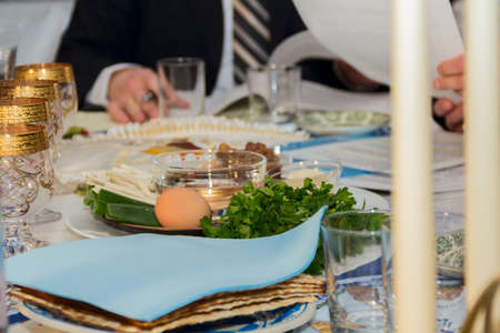 seder table with Passover plate, and special meal with egg, parsleyの写真素材