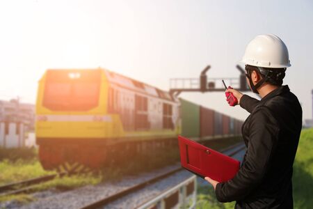 Foreman stood to inspect container trains Unload goods from the port. Radio communication with the train captain. wlakie talkieの写真素材