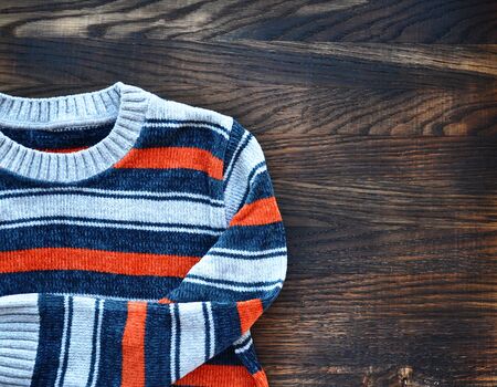 Striped sweater on wooden background. Top view.の写真素材