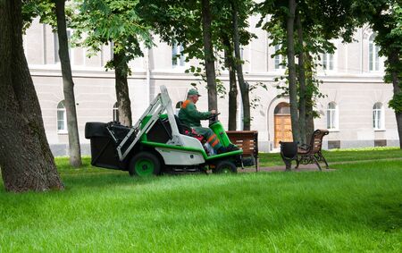 Chernihiv / Ukraine - 05/21/2020: worker on a lawn mower mows the grass in the park
