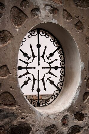 narrow grating window in an old building for your designの写真素材
