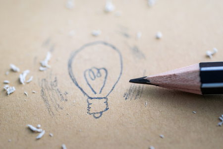 Drawing a cartoon light bulb with pencilの写真素材