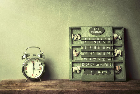 green wood calendar vintage and alarm clock on wood table end of the year or happy new year 2017 concept.の写真素材