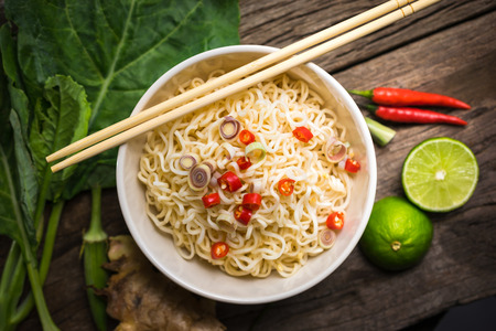spicy Instant noodles with Vegetable in a bowl on wood board.