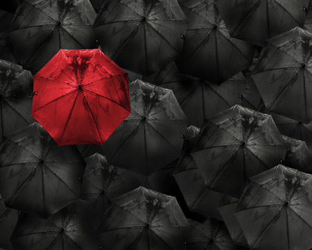 Red umbrella with water drop stand out from the crowd of many black umbrellas above view Business and leader conceptの写真素材