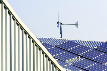 solar cell panel and wind turbines on factory roofの写真素材
