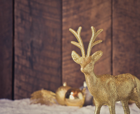 christmas gold reindeer decoration with wood backgroundの写真素材