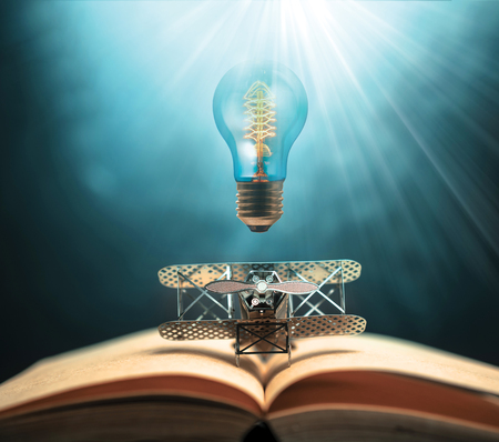 antique edison style filament light bulbs and aircraft figther on open book with abstract light studious student, education, concept.の写真素材