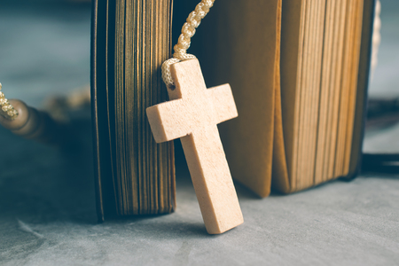 Catholic rosary beads with old book on cement table prayer, rosary background concept in vintage tone.の写真素材