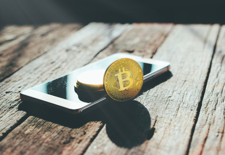 golden bitcoin coin on mobile phone crypto Currency background conceptの写真素材