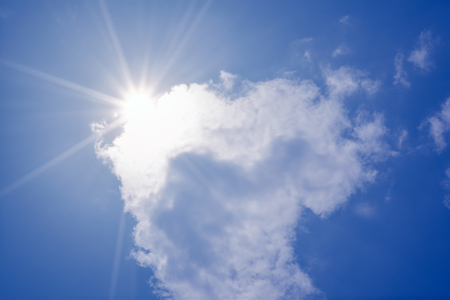 blue sky with clouds and sun reflection.The sun shines bright in the daytime in summerの写真素材