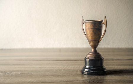 Trophy cup on the wooden table with copy space for your textの写真素材