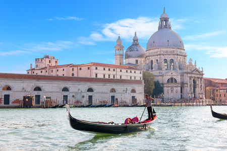 Venice, Italy - August 22, 2018: Gondolier in a gondola in front of Basilica Santa Maria della Saluteのeditorial素材