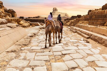 Tourists on camels in the temple of Giza near the Great Sphinx, Egypt.の写真素材